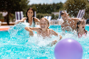 Ball,In,Pool.,Cheerful,Happy,Parents,And,Children,Laughing,While